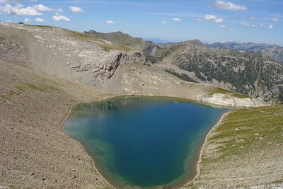 Le lac de la Petite Cayolle en été, dans sa combe minérale, vue plongeante vers le haut-Verdon.