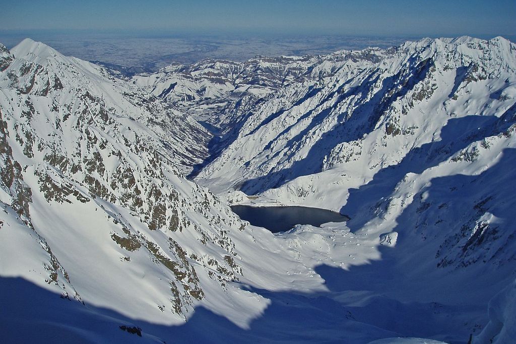 Randonnée Argentera. A gauche, la cime pointue et enneigée du Chiapous, (2805 m), et le lac artificiel de la Chiotas.