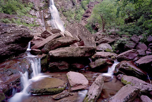 Cascade d'Amen dans la clue du même nom. Blocs de pélites rouge entassés par les crues. Etiage estival.